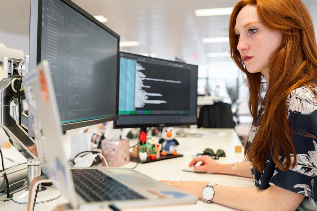 Woman working on in an office in front of her computer typing on her keyboard